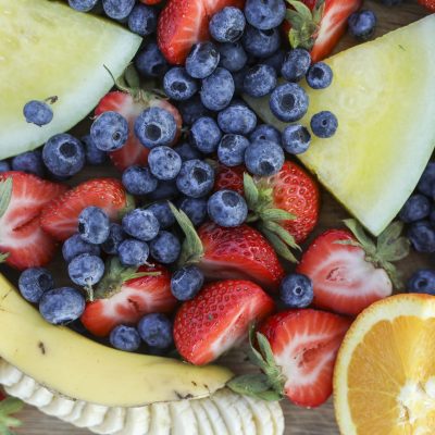 Fresh fruits on a wooden board at a picnic